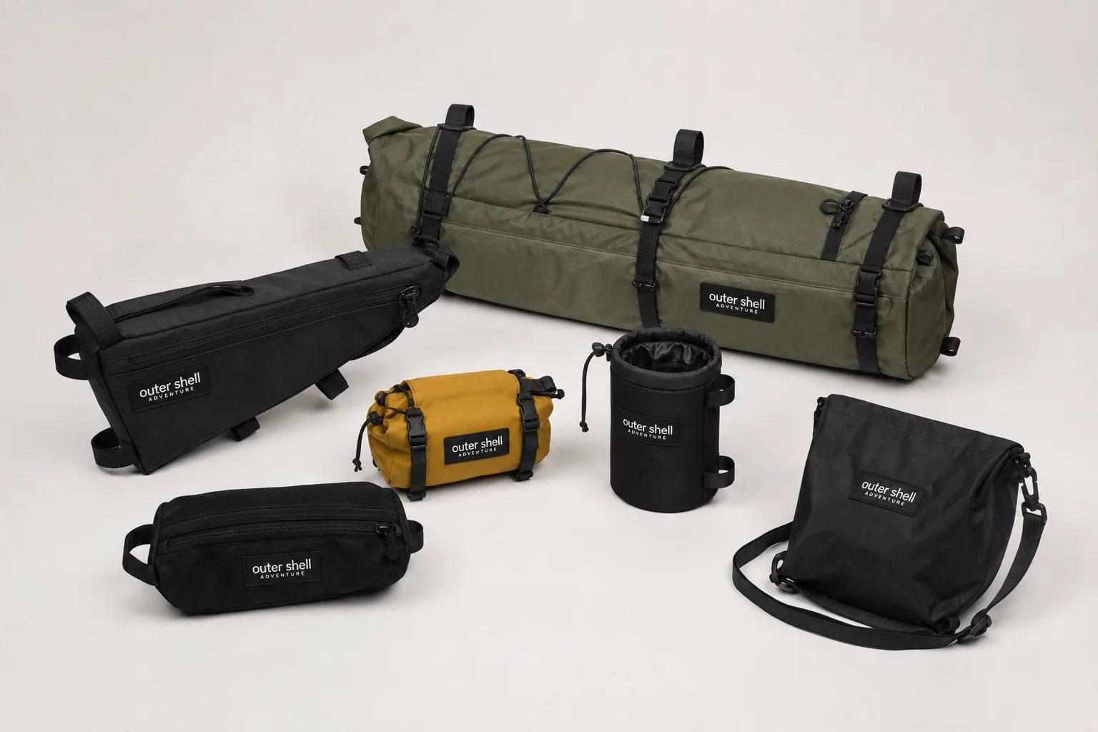 Sei borse da bikepacking Outer Shell di vari colori e dimensioni su uno sfondo neutro
