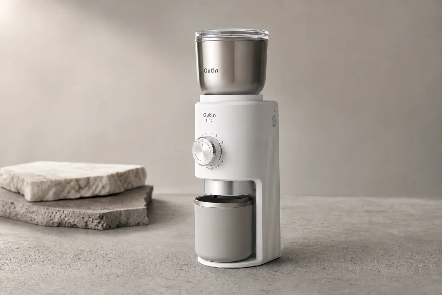 OutIn Fino portable electric coffee grinder on matte concrete surface