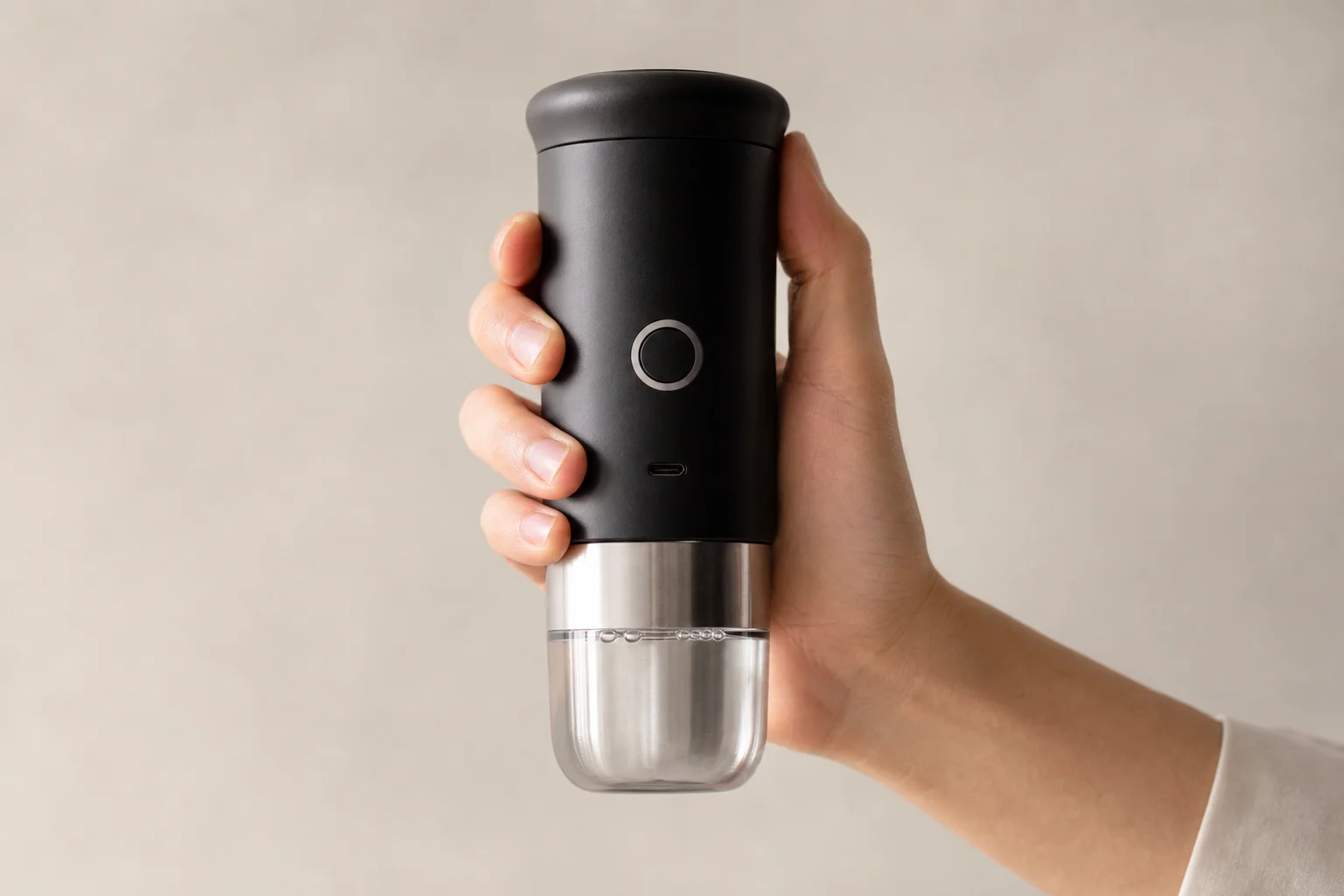 Hand holding Outin Mino espresso maker showing compact size