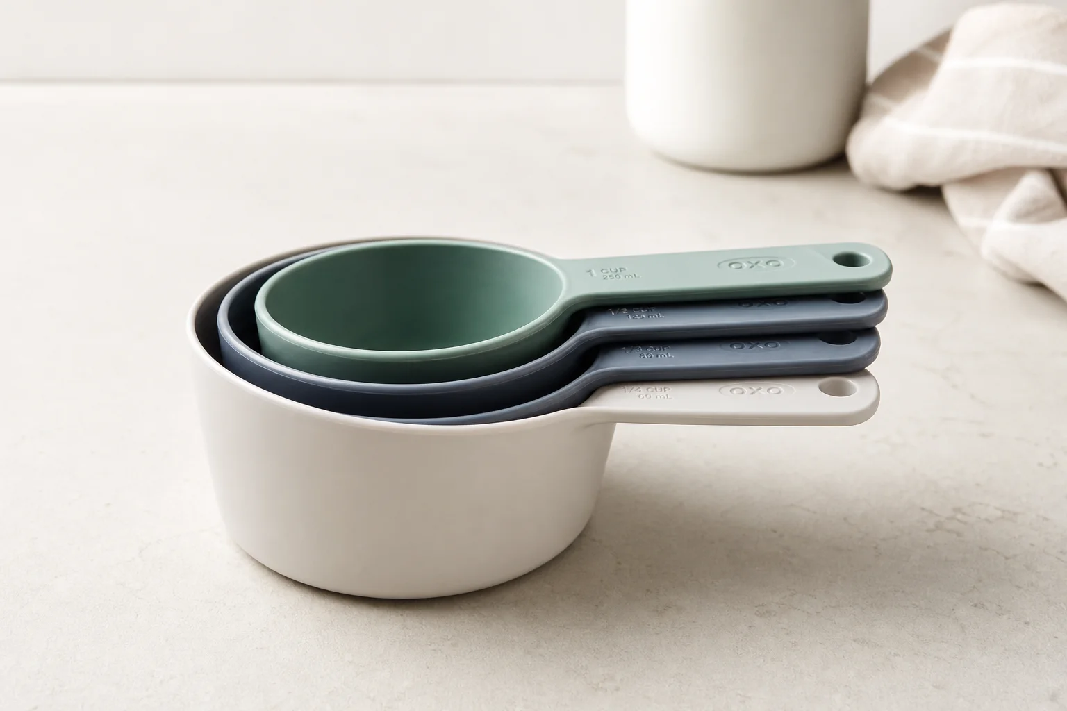 Eight essential kitchen tools arranged on a light wood surface