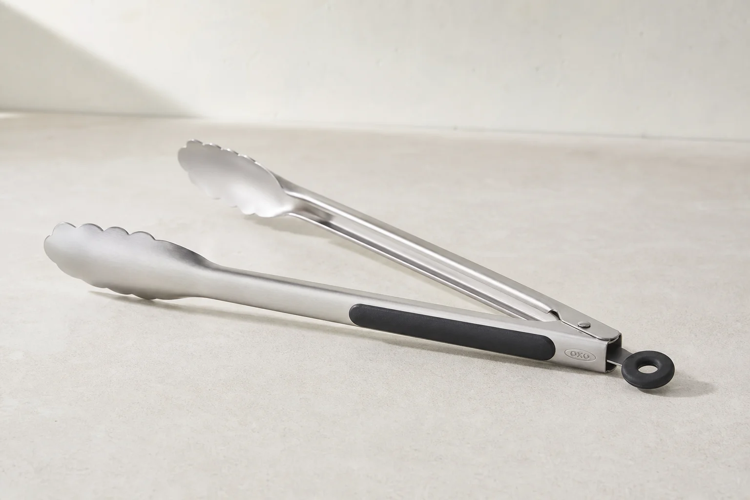Eight essential kitchen tools arranged on a light wood surface