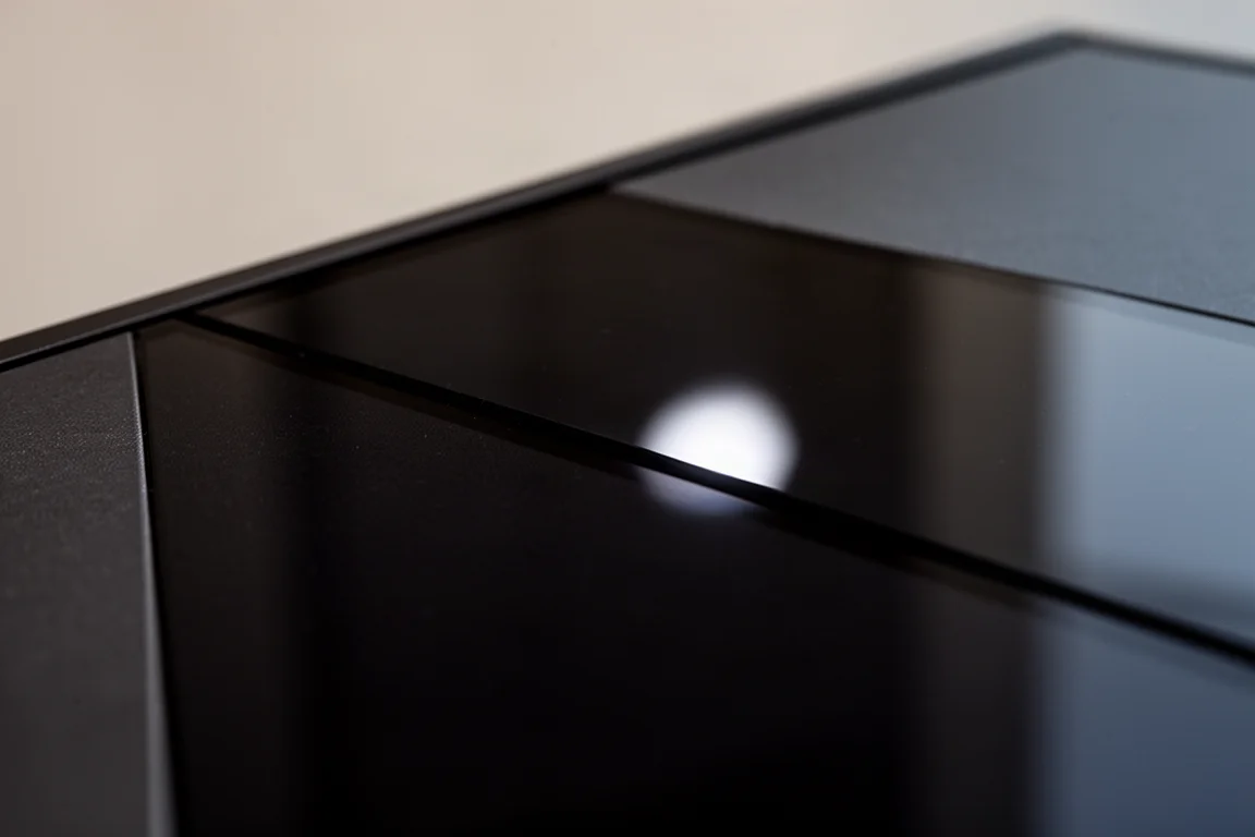 Gros plan sur une surface d'écran sombre et brillante avec un seul reflet lumineux