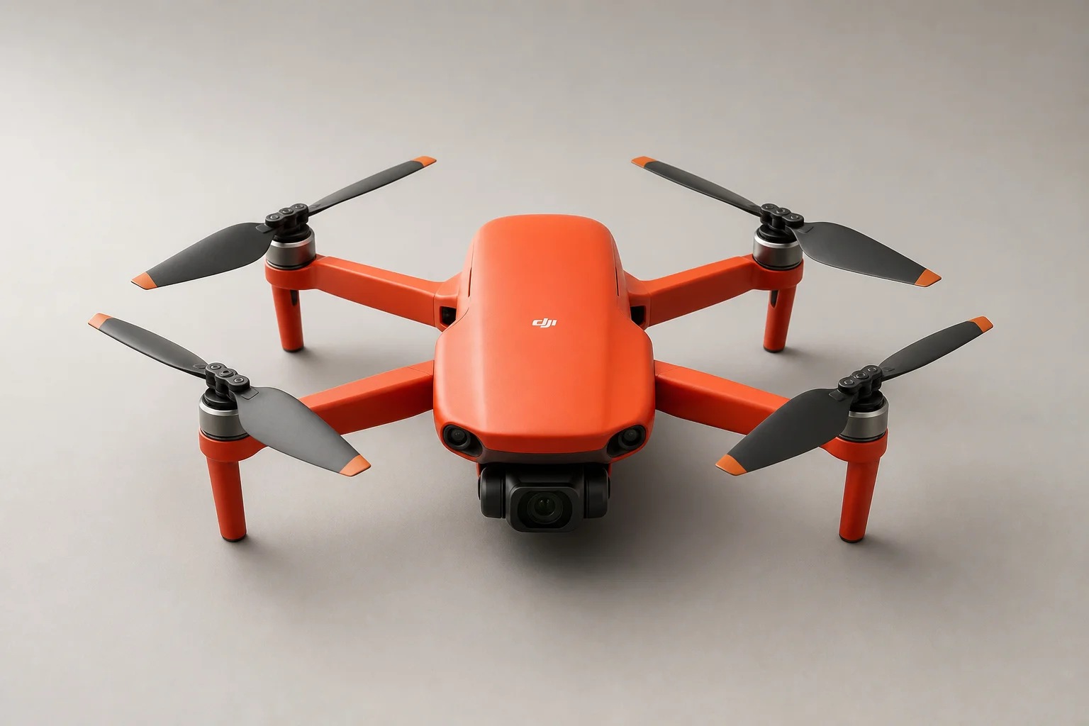 Cinq drones d'entrée de gamme disposés sur une surface en béton gris