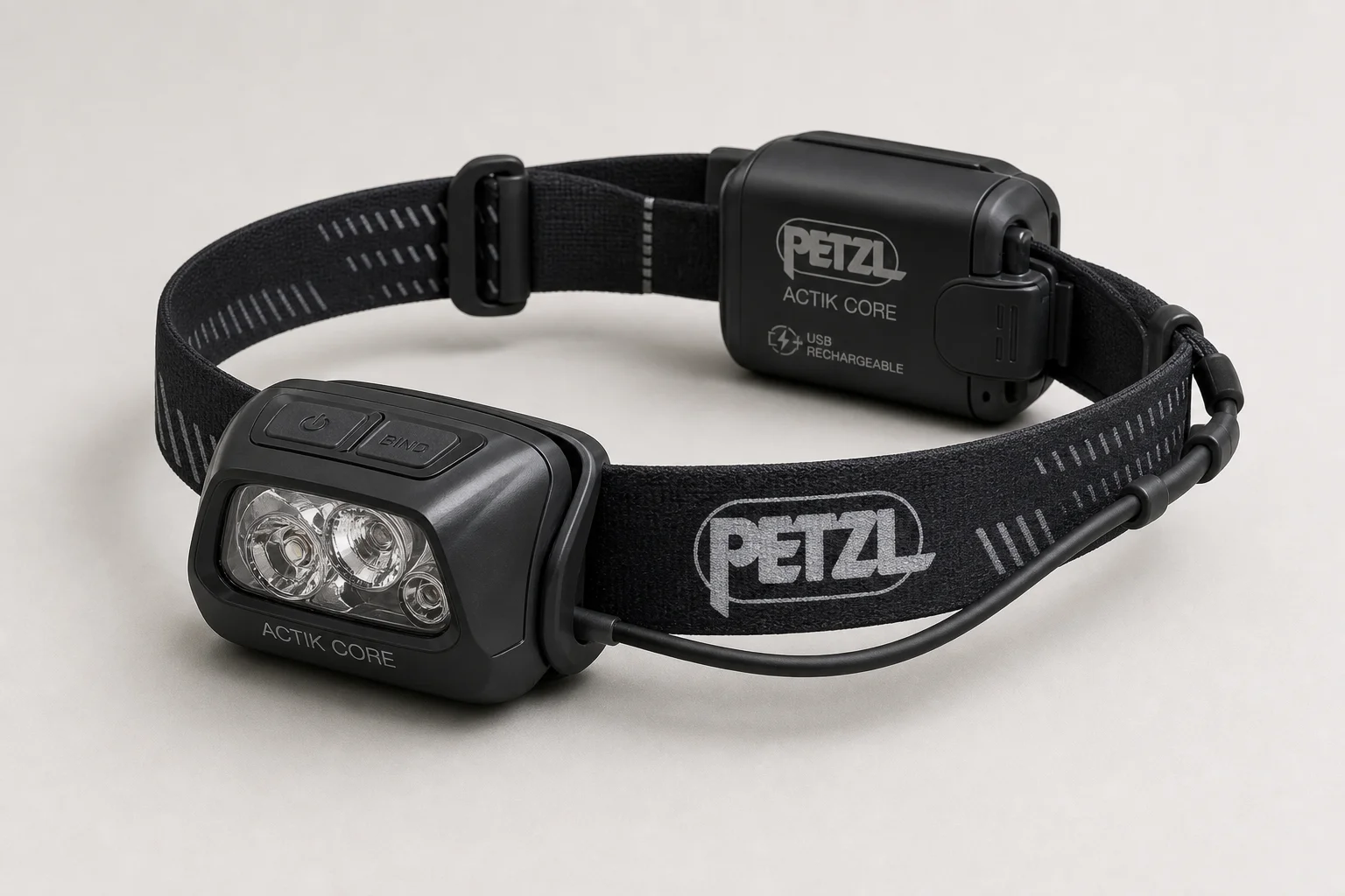 Four headlamps arranged on concrete: Black Diamond Spot 325, Petzl Tikkina, Petzl Actik Core, and BioLite Headlamp 330