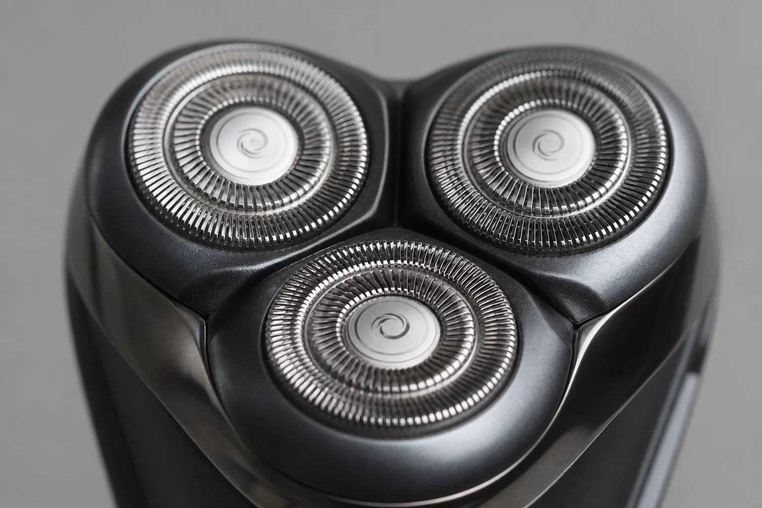 Close-up of rotary shaver head with three blades in triangular pattern