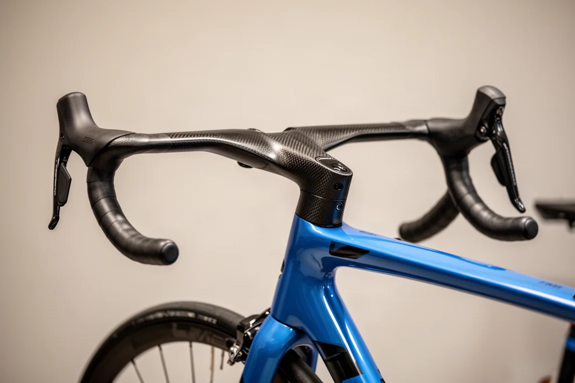 Hands resting on narrow flared handlebar drops of an integrated road cockpit