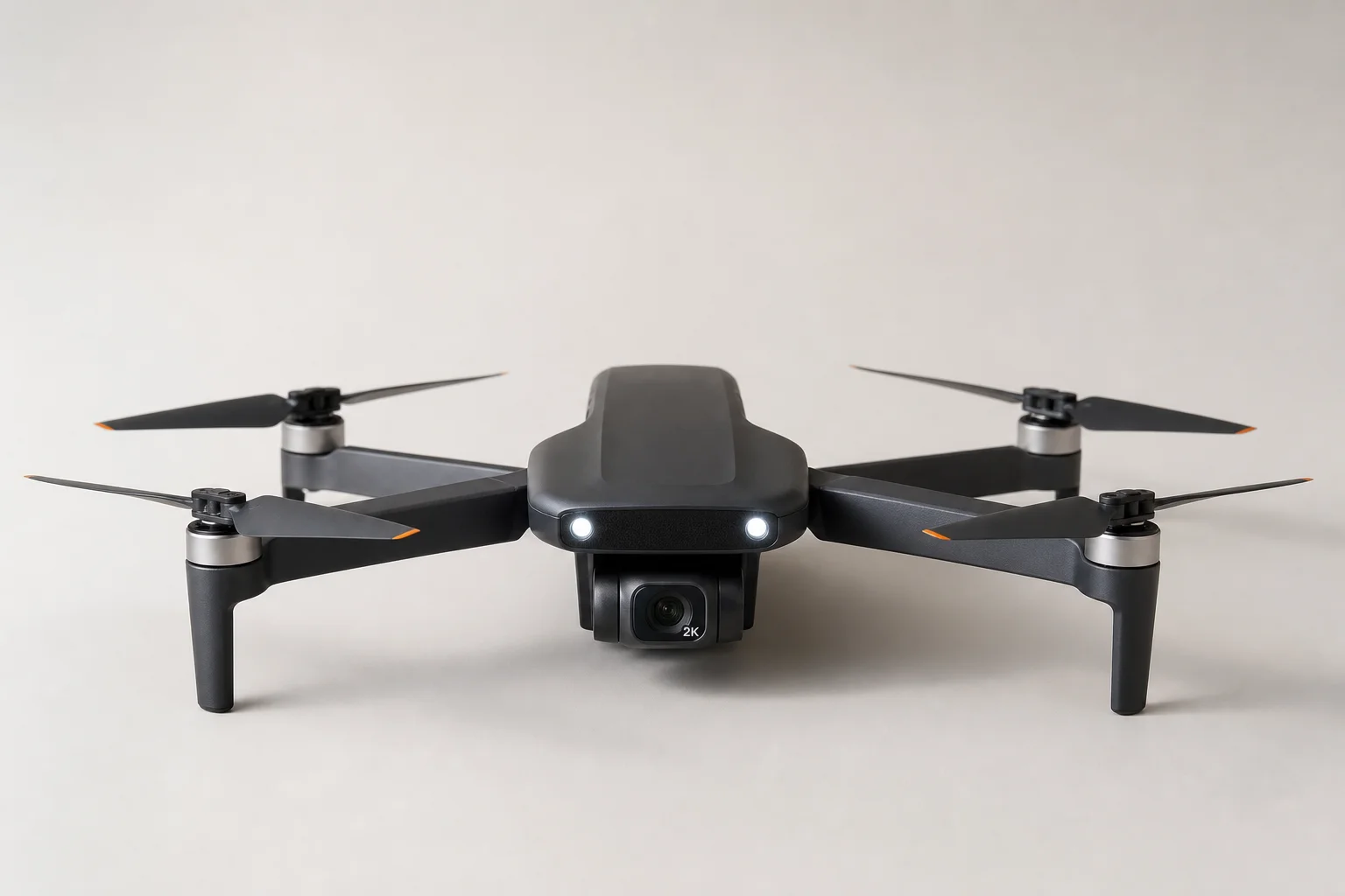 Cinq drones d'entrée de gamme disposés sur une surface en béton gris