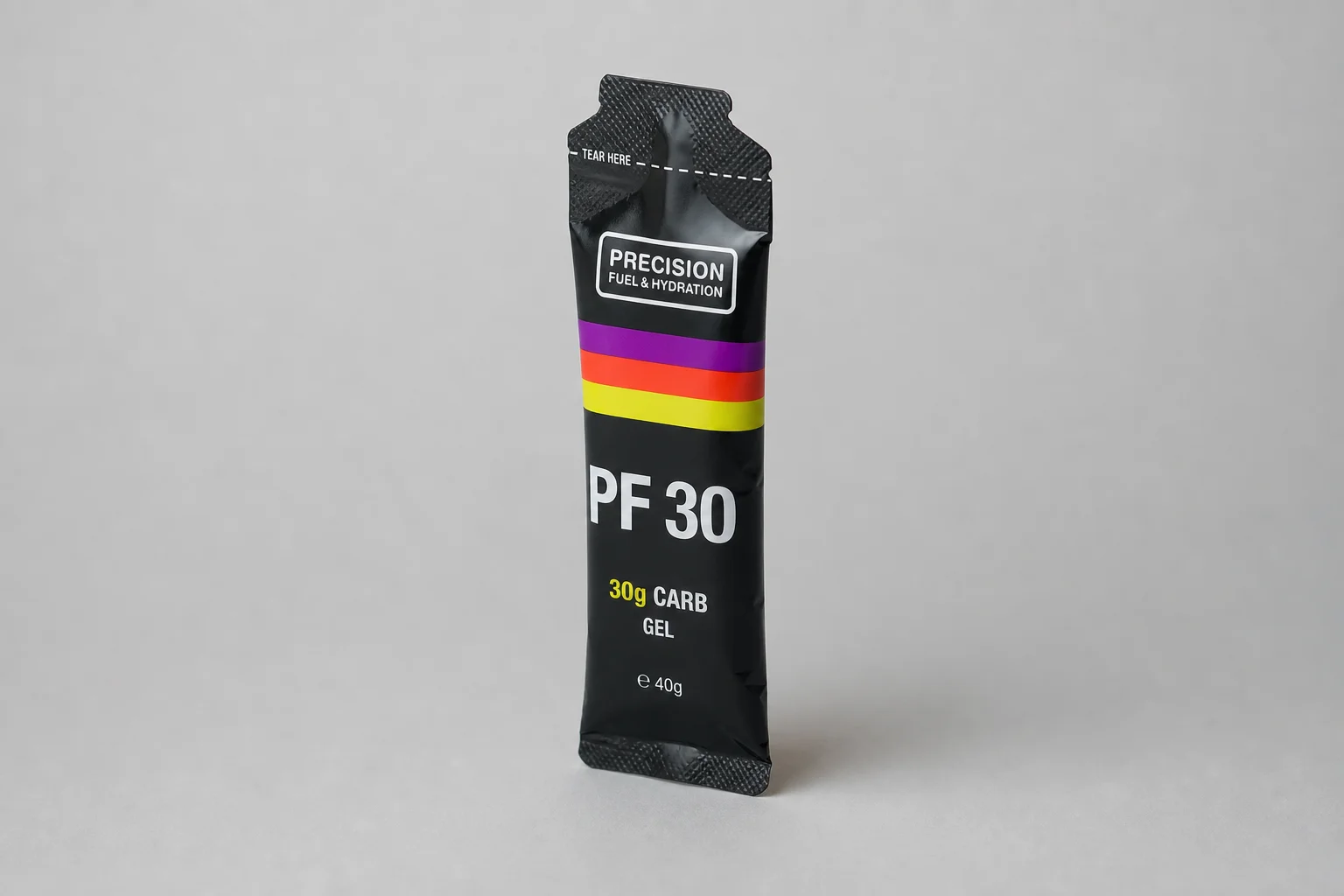 Thirteen energy gel packets arranged in a grid on concrete surface