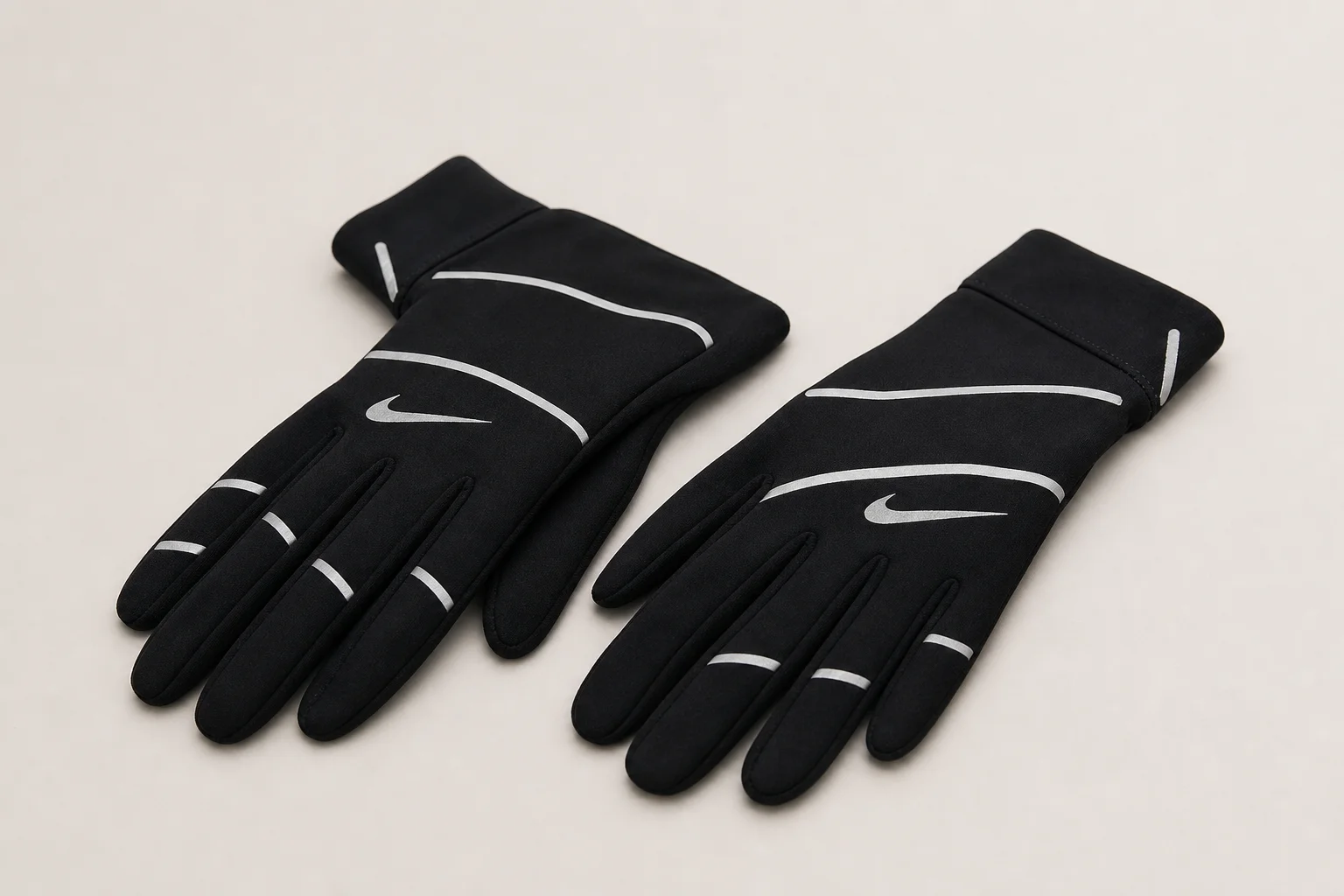Winter-Laufzubehör auf Beton, darunter Handschuhe, Mütze, Stirnlampe und ein reflektierender Rucksack