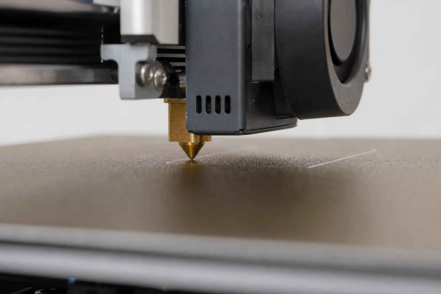 Buse d'imprimante 3D effectuant le calibrage de la première couche sur le plateau chauffant