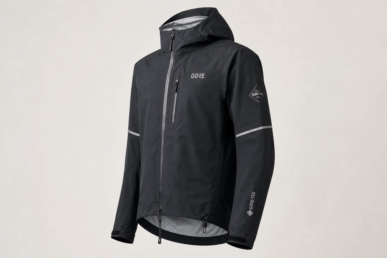 Cinq vestes de pluie pour cyclisme de différentes couleurs disposées sur un fond neutre