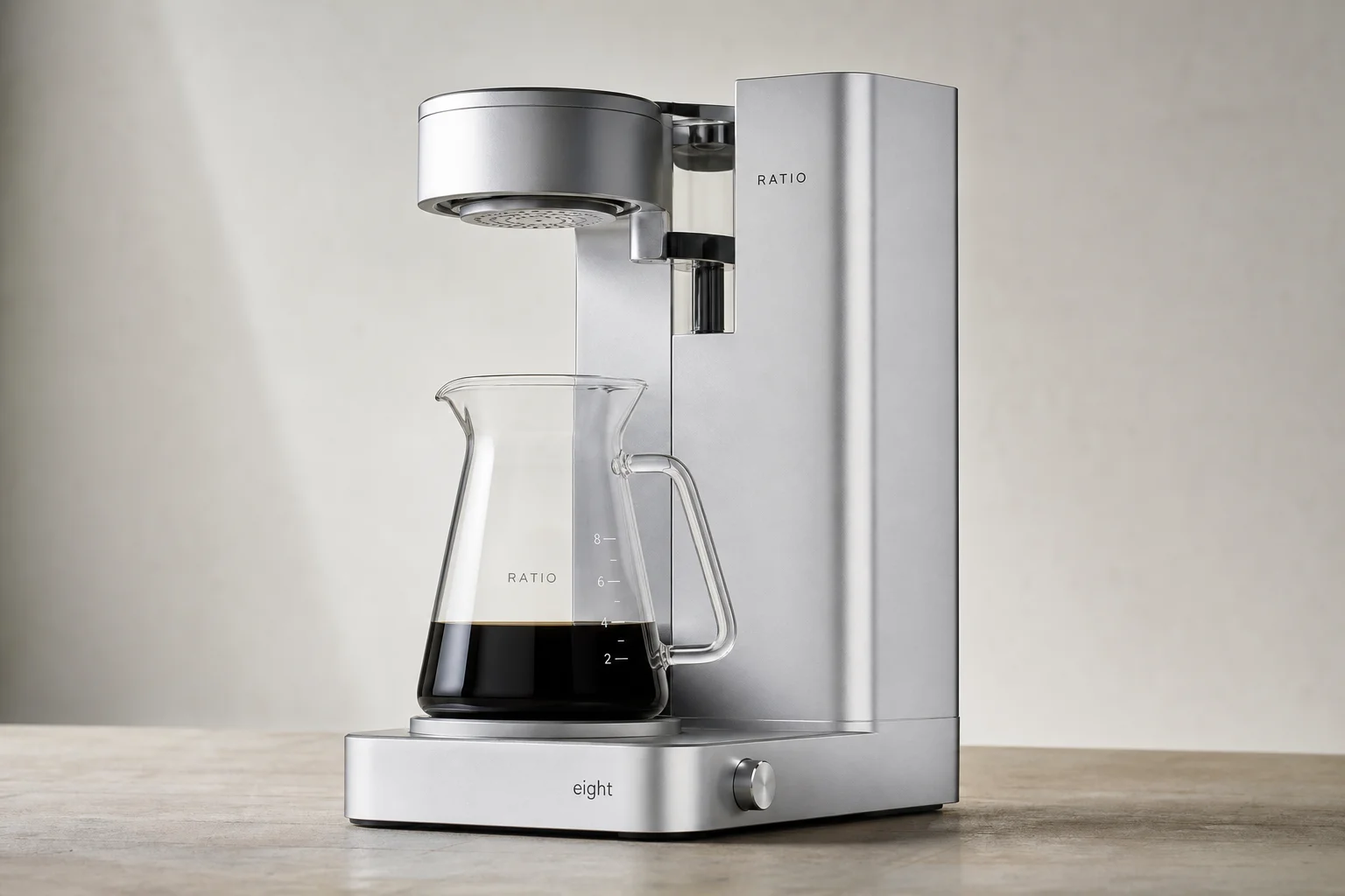 Six non-toxic coffee makers arranged on concrete: percolator, Chemex, La Pavoni, Flair Pro 3, Bunn VP17, and Ratio 8