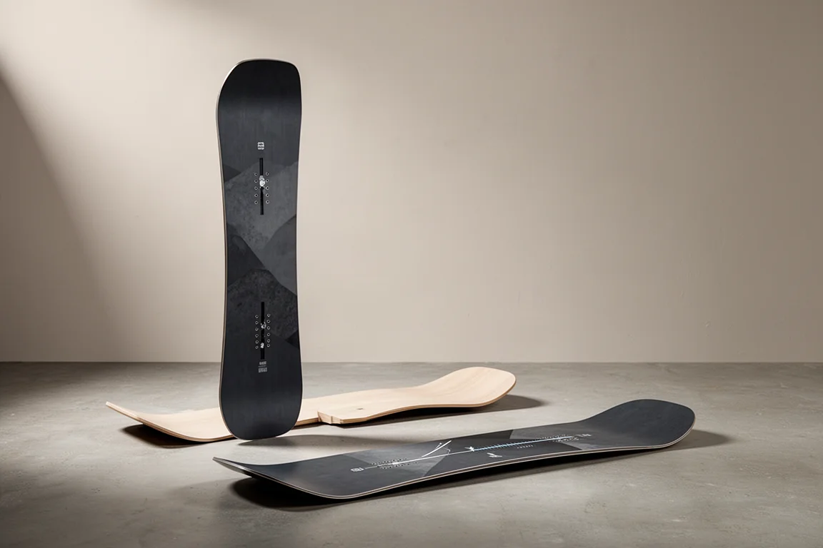 Richtungsorientiertes Snowboard aufrecht auf Beton stehend, ein zweites Board liegend daneben