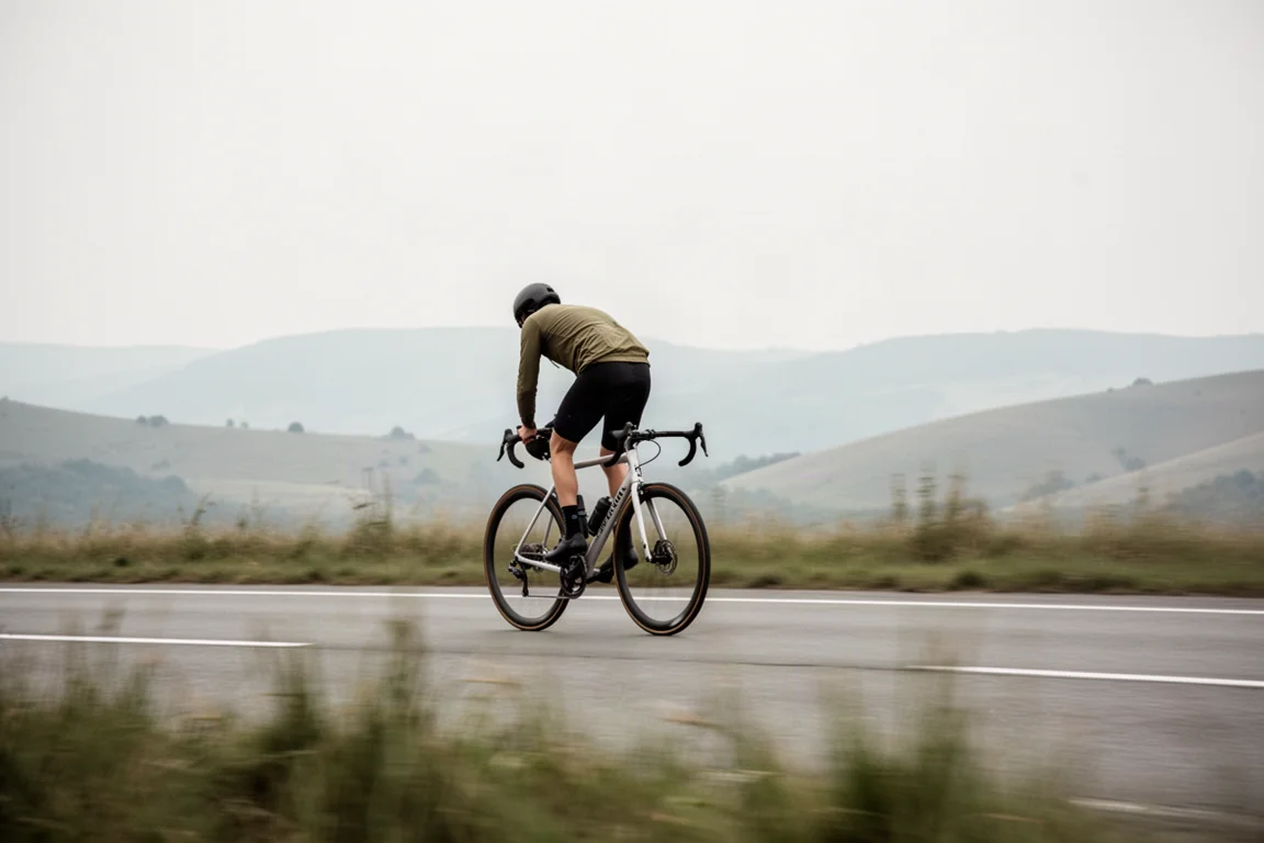 Wielrenner houdt een gelijkmatig tempo aan op een carbon racefiets op de open weg