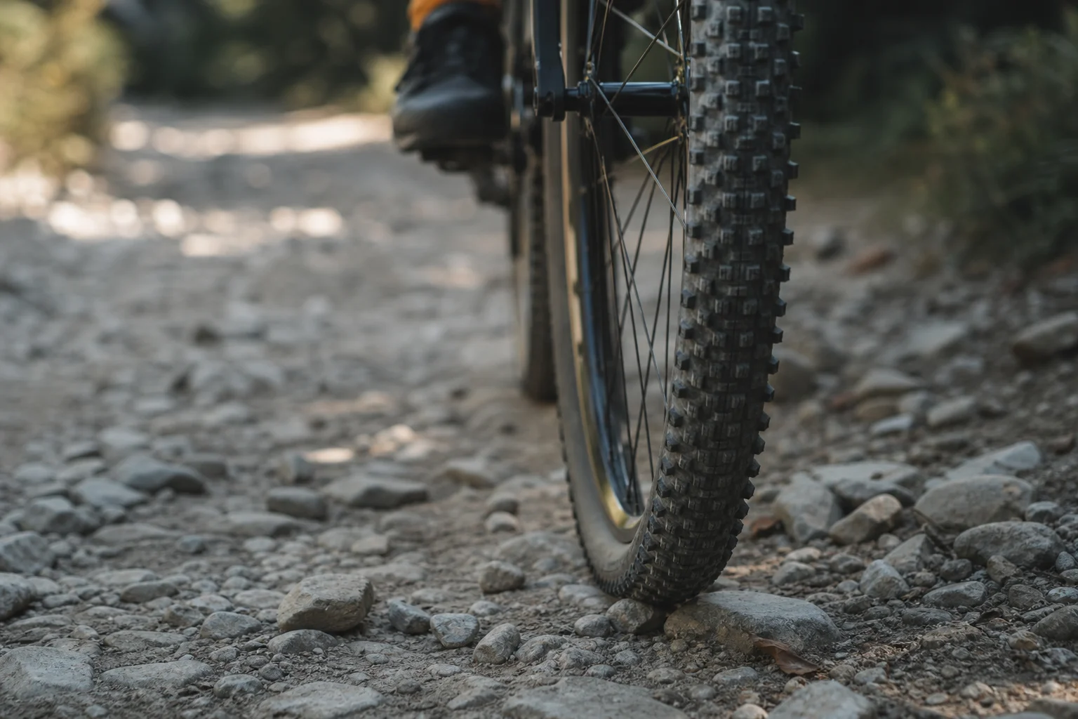 Neumático de bicicleta de gravel en terreno rocoso sin pavimentar con luz natural