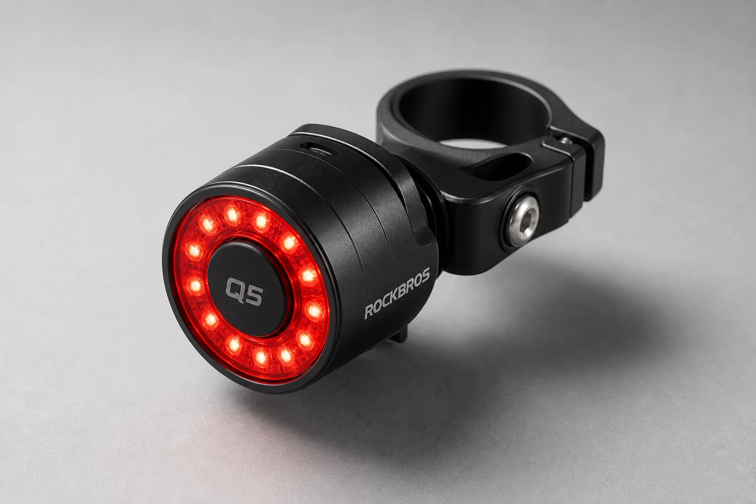 Luce posteriore per bici RockBros Q5 montata su morsetto in alluminio su una superficie grigia
