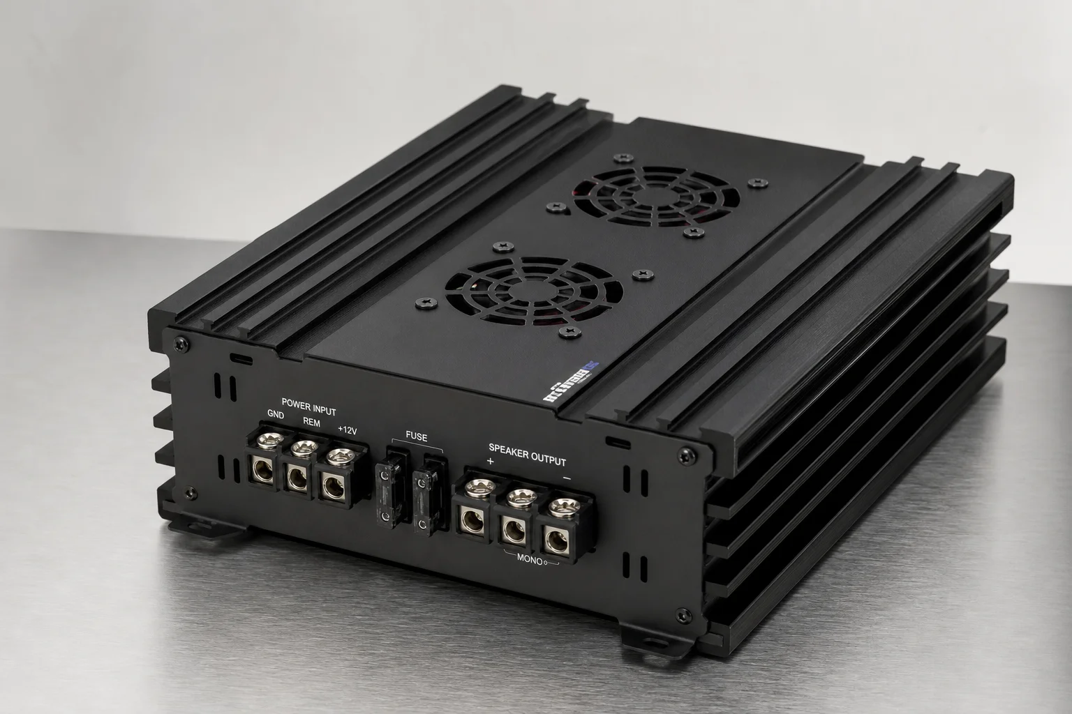 Sette amplificatori mono per auto disposti su una superficie in alluminio spazzolato