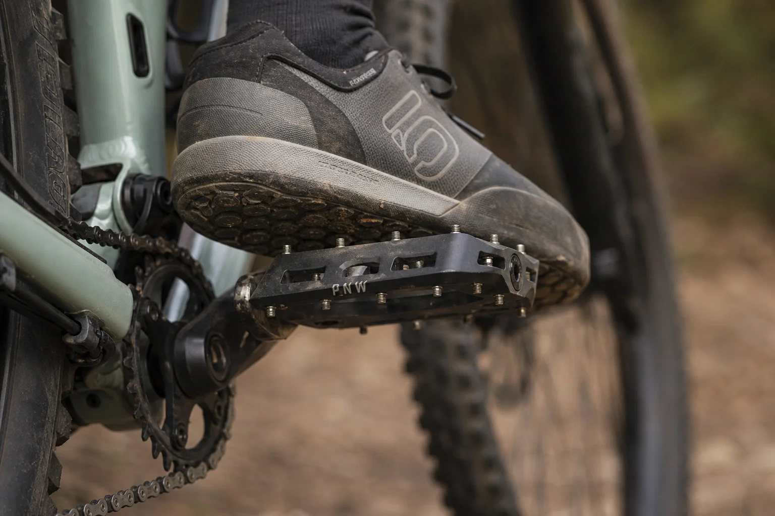 Nahaufnahme von Plattformpedalen mit Grip-Pins an einem Mountainbike während der Fahrt