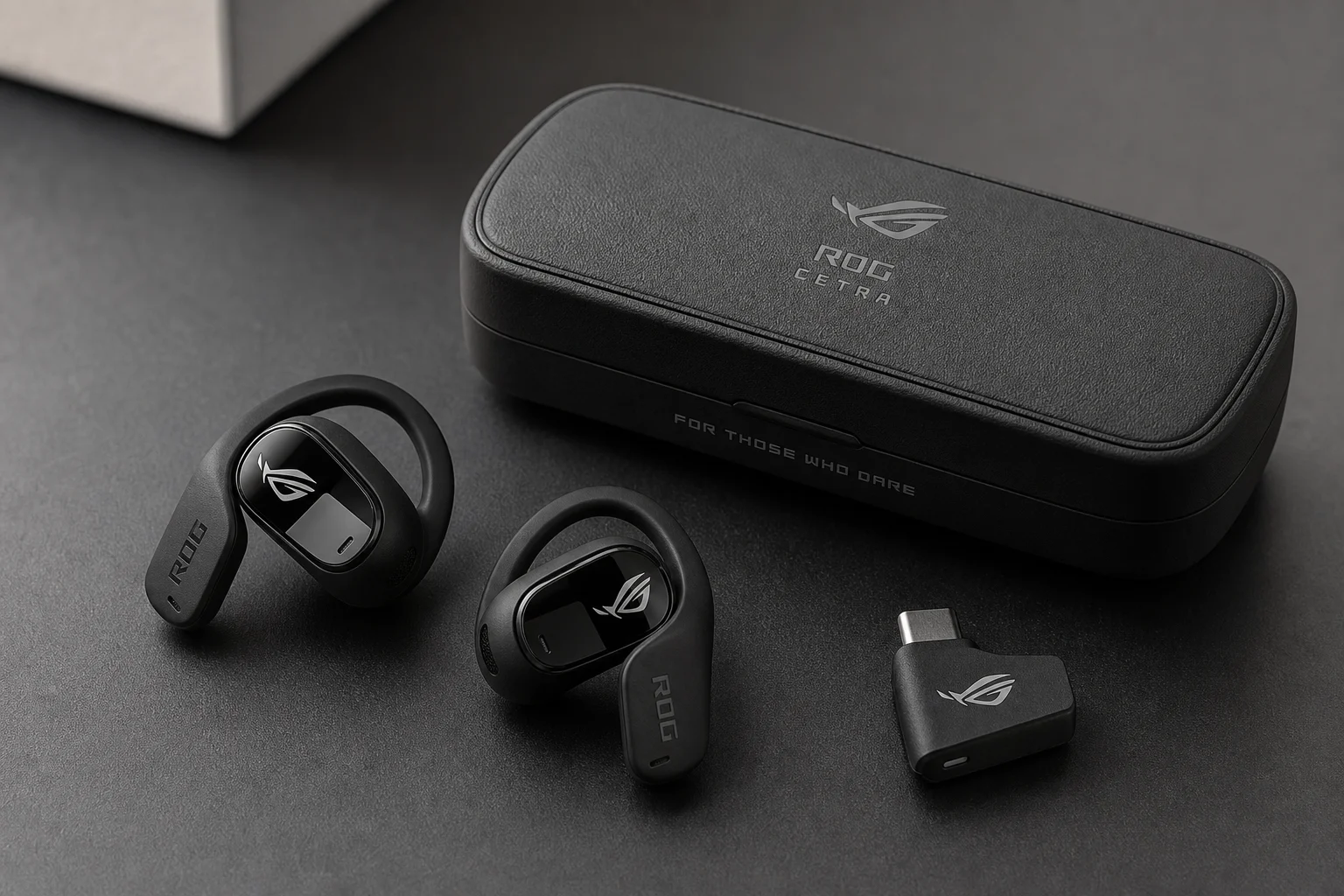 ROG Cetra Open Wireless earbuds, charging case, and 2.4GHz dongle on matte black surface