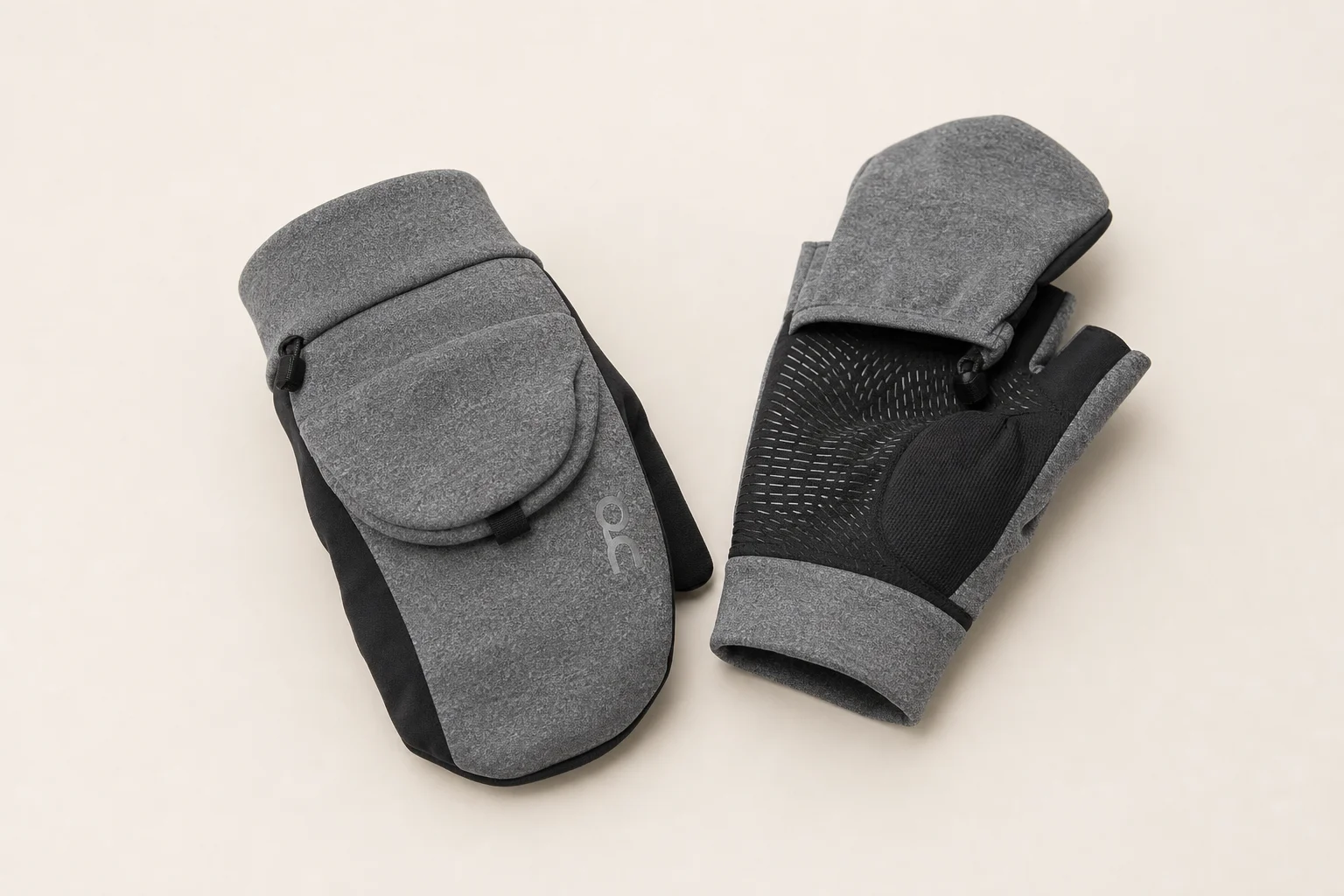 Winter-Laufzubehör auf Beton arrangiert, darunter Handschuhe, Mütze, Stirnlampe und ein reflektierender Rucksack