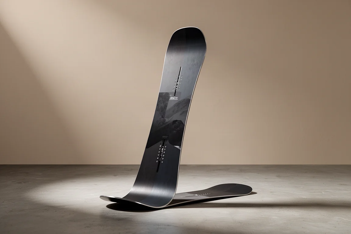 Twin-Tip-Snowboard auf einem matten Betonboden in weichem Studiolicht aufrecht stehend