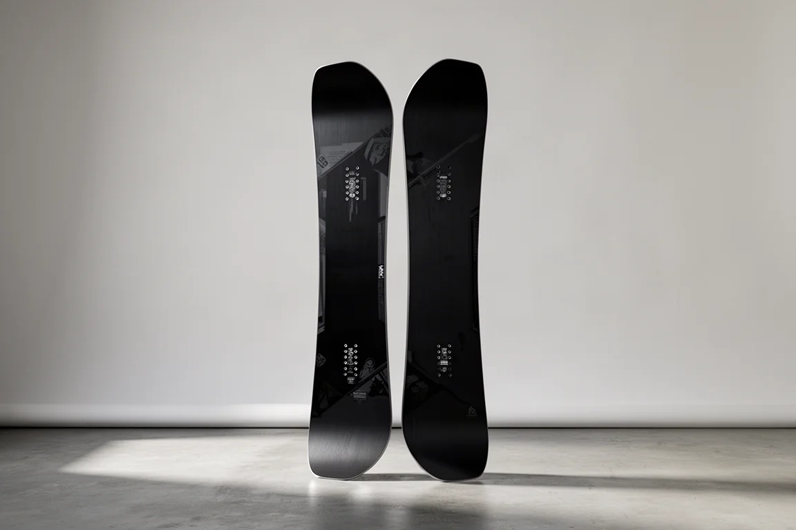 Deska snowboardowa freestyle stojąca pionowo z widocznym profilem camber i rockerem w nosie i tailu