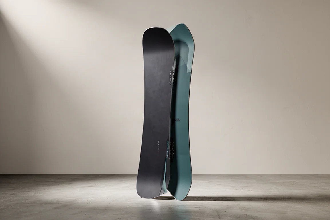 Riktad all-mountain-snowboard som står upprätt på en matt betongyta