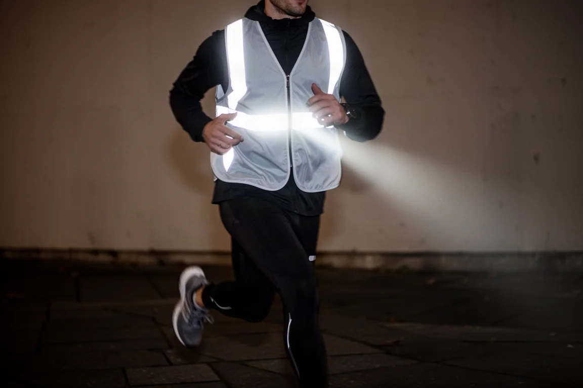 Reflective safety vest glowing under car headlights at night