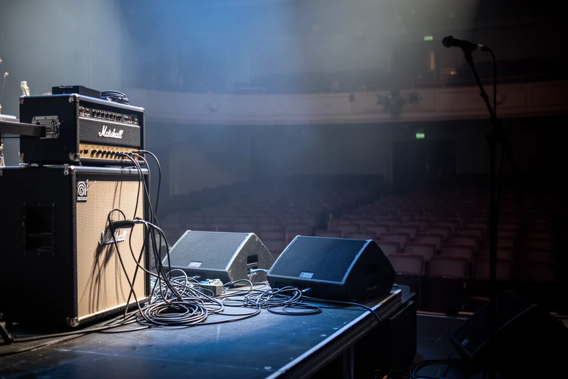 Escenario en la prueba de sonido con un equipo de bajo y monitores bajo luz azul