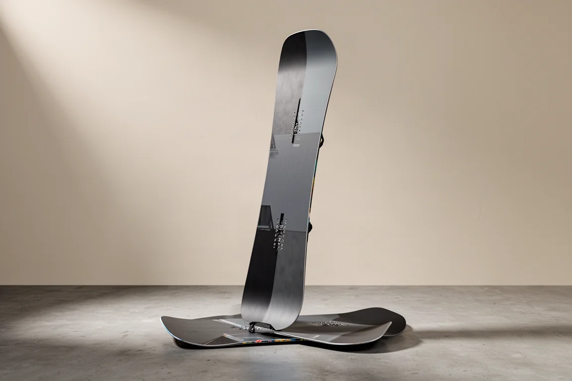 Salomon Assassin all-mountain snowboard standing at a three-quarter angle on a wooden floor