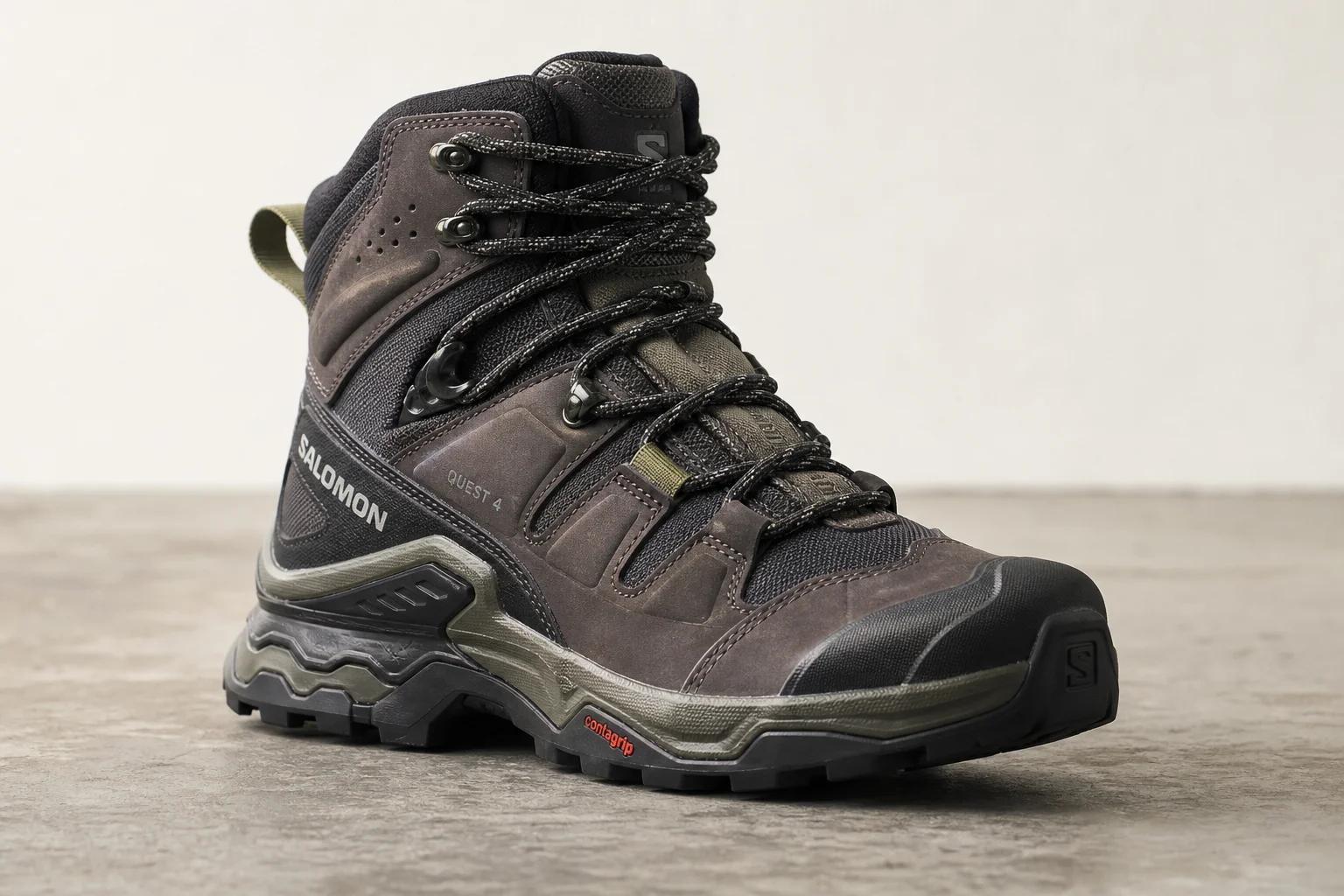 Seven hiking boots arranged on concrete surface representing different styles and purposes