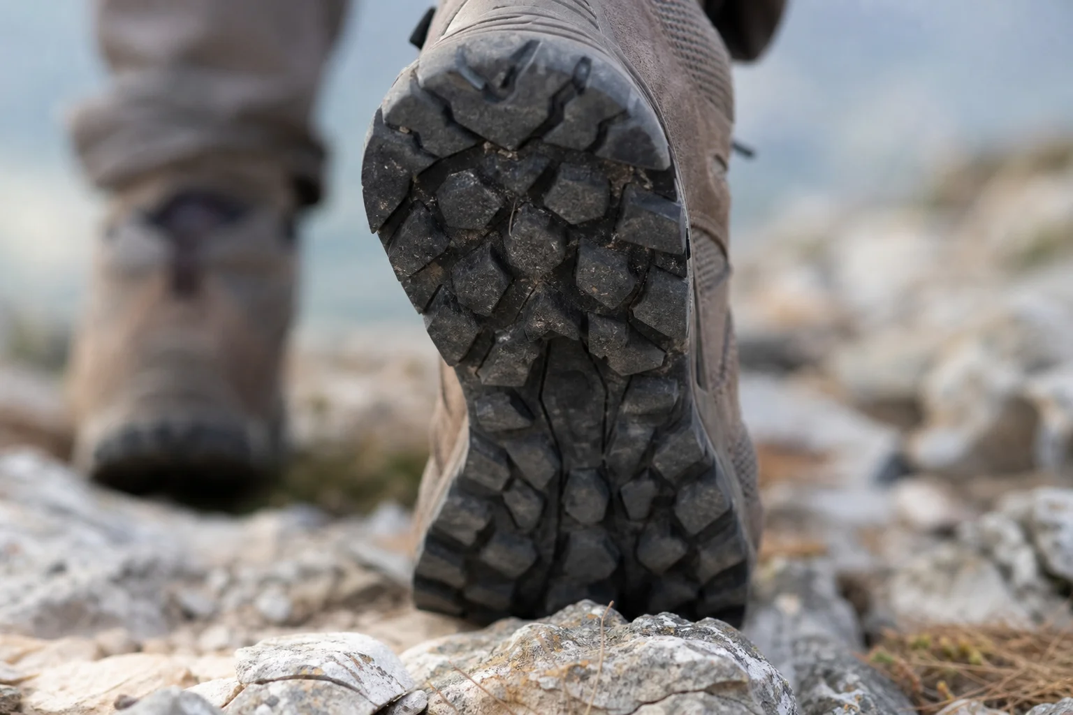 Nahaufnahme des Profils eines Wanderschuhs auf felsigem Untergrund