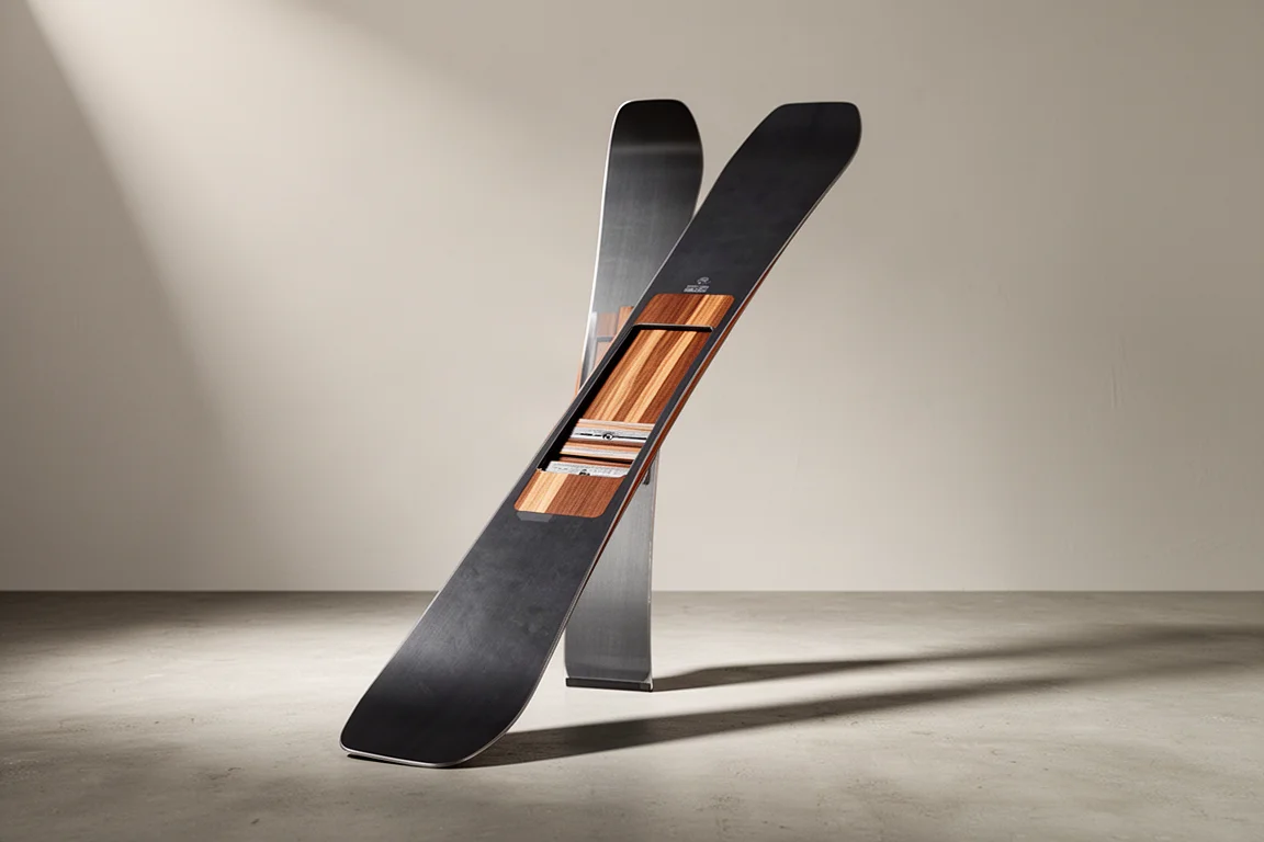 Sci freeride largo in piedi su una superficie di cemento opaco con luce da studio soffusa