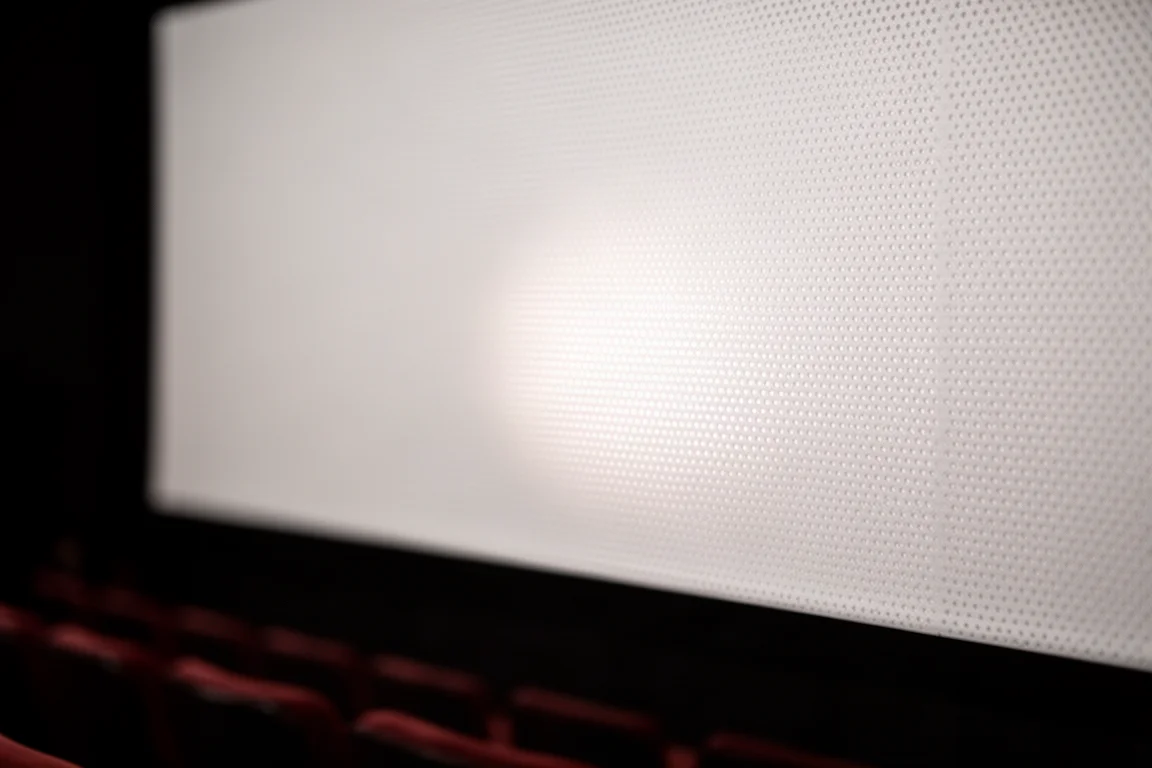 Primer plano del material de pantalla de proyección de vinilo perforado blanco mate con luz atravesándolo
