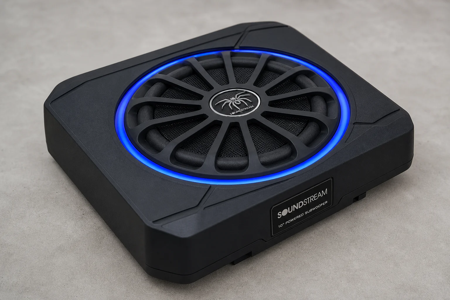 Six underseat subwoofers of varying sizes arranged on concrete surface