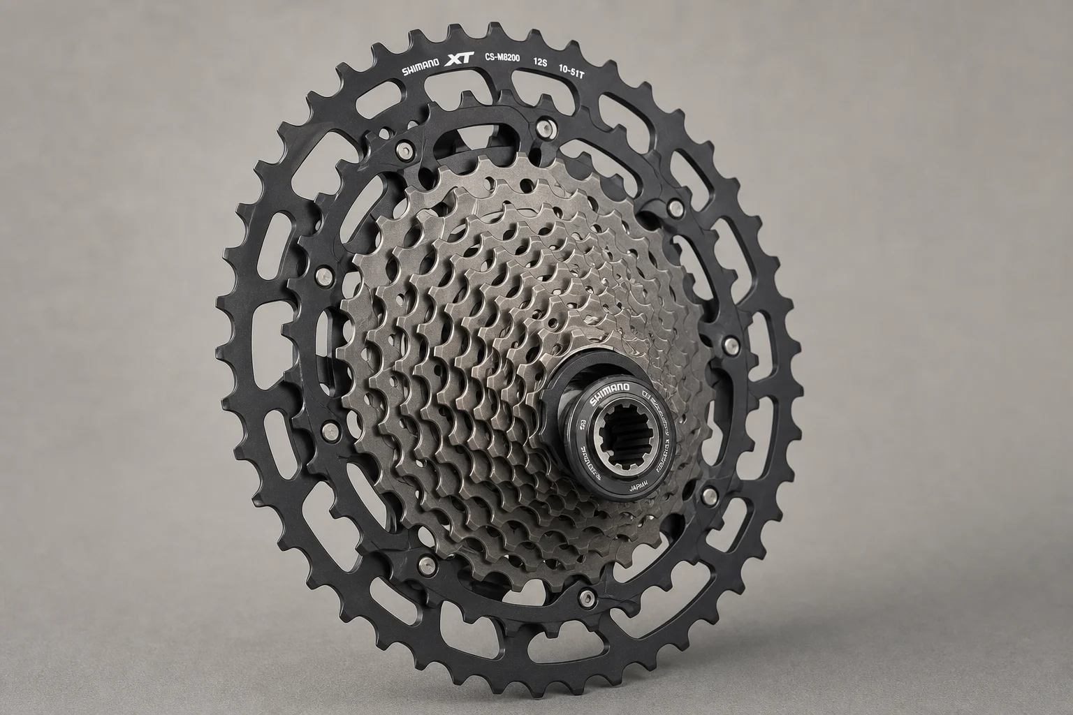 Shimano XT M8200 12-speed cassette with dark gray aluminum cogs and Micro Spline interface on neutral background