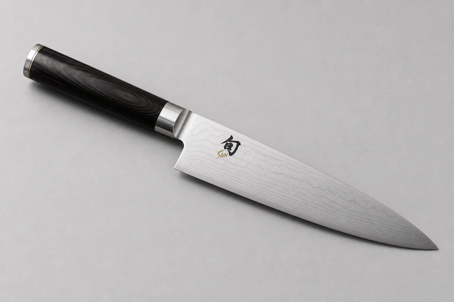 四把主廚刀斜向排列在混凝土面上：Misen、Made-In、Victorinox 與 Shun