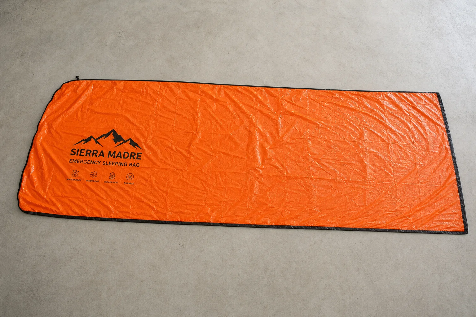 Saco de dormir de emergencia extendido mostrando sus dimensiones completas y el exterior naranja brillante