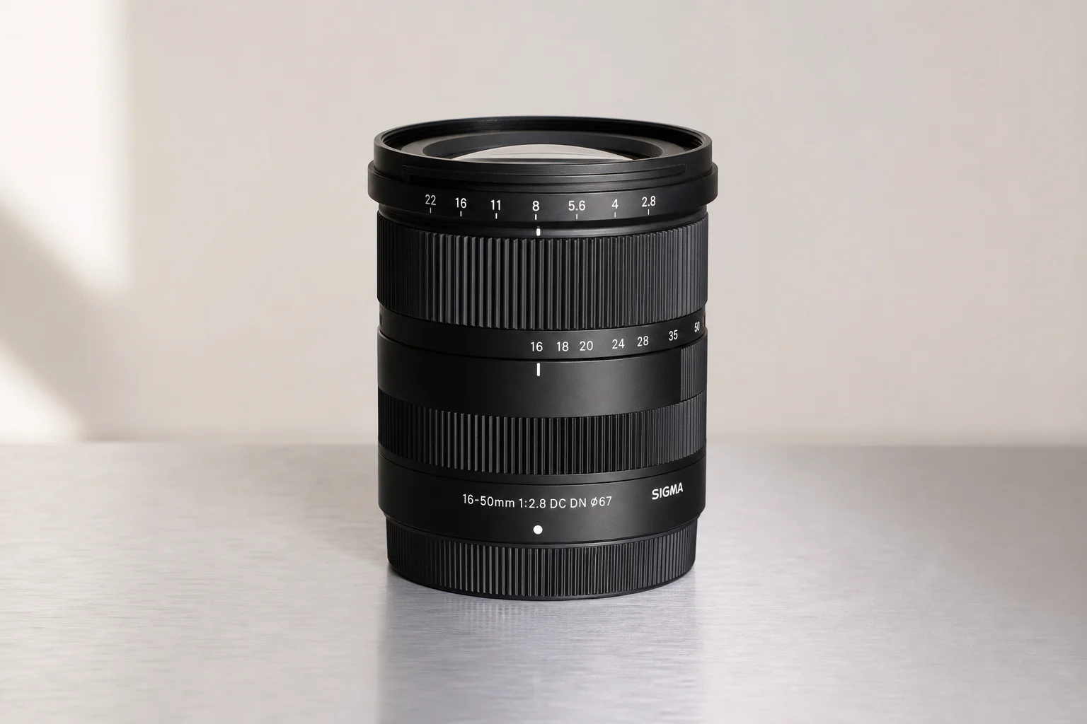 Sony A6400 無反光鏡相機安裝變焦鏡頭，放置於髮絲紋鋁合金表面上
