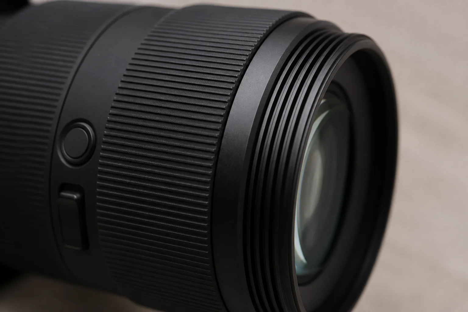 Close-up detail of lens barrel showing focus ring, control buttons, and filter thread