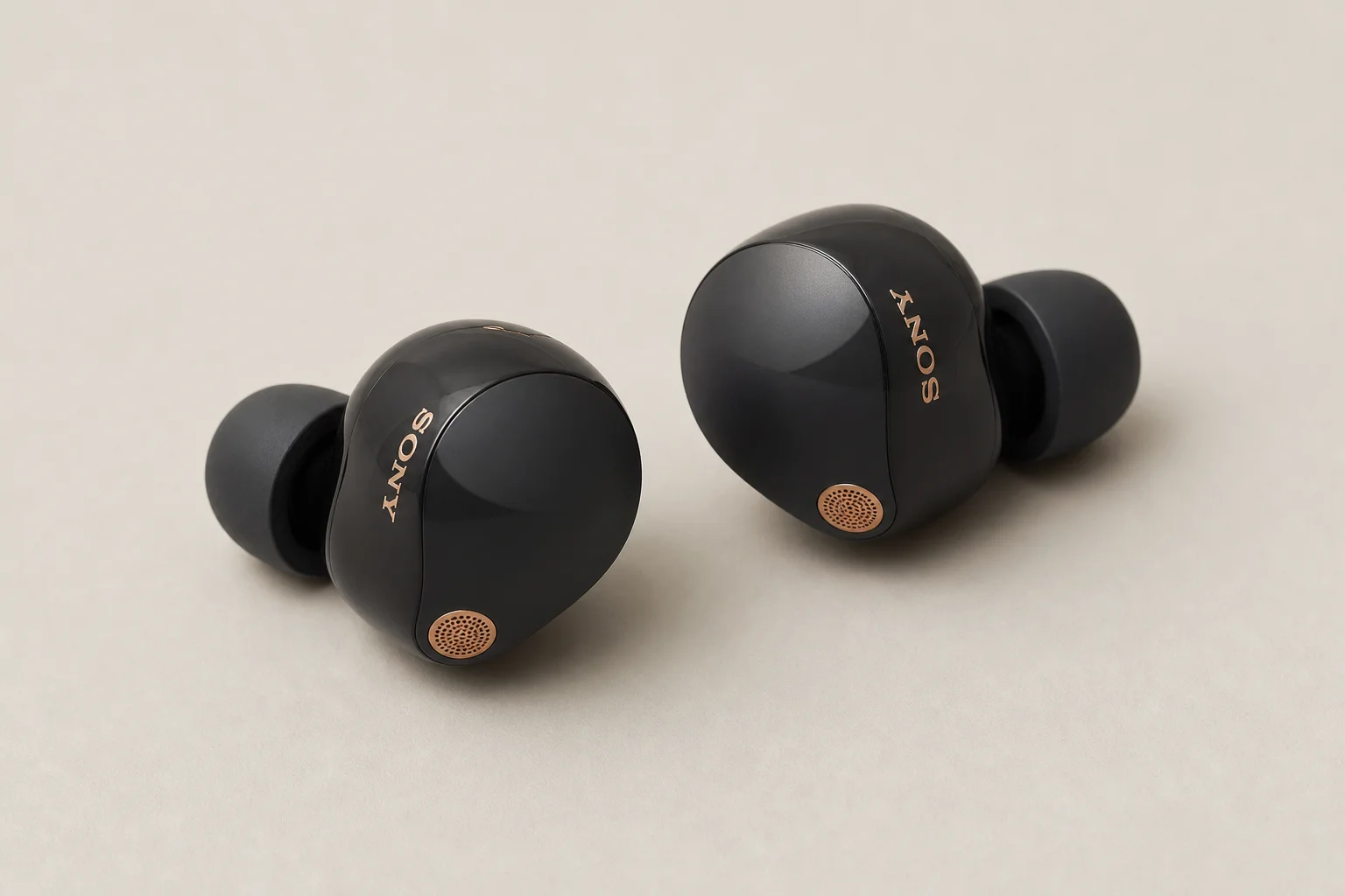 Collection de 12 écouteurs true wireless disposés sur une surface en béton