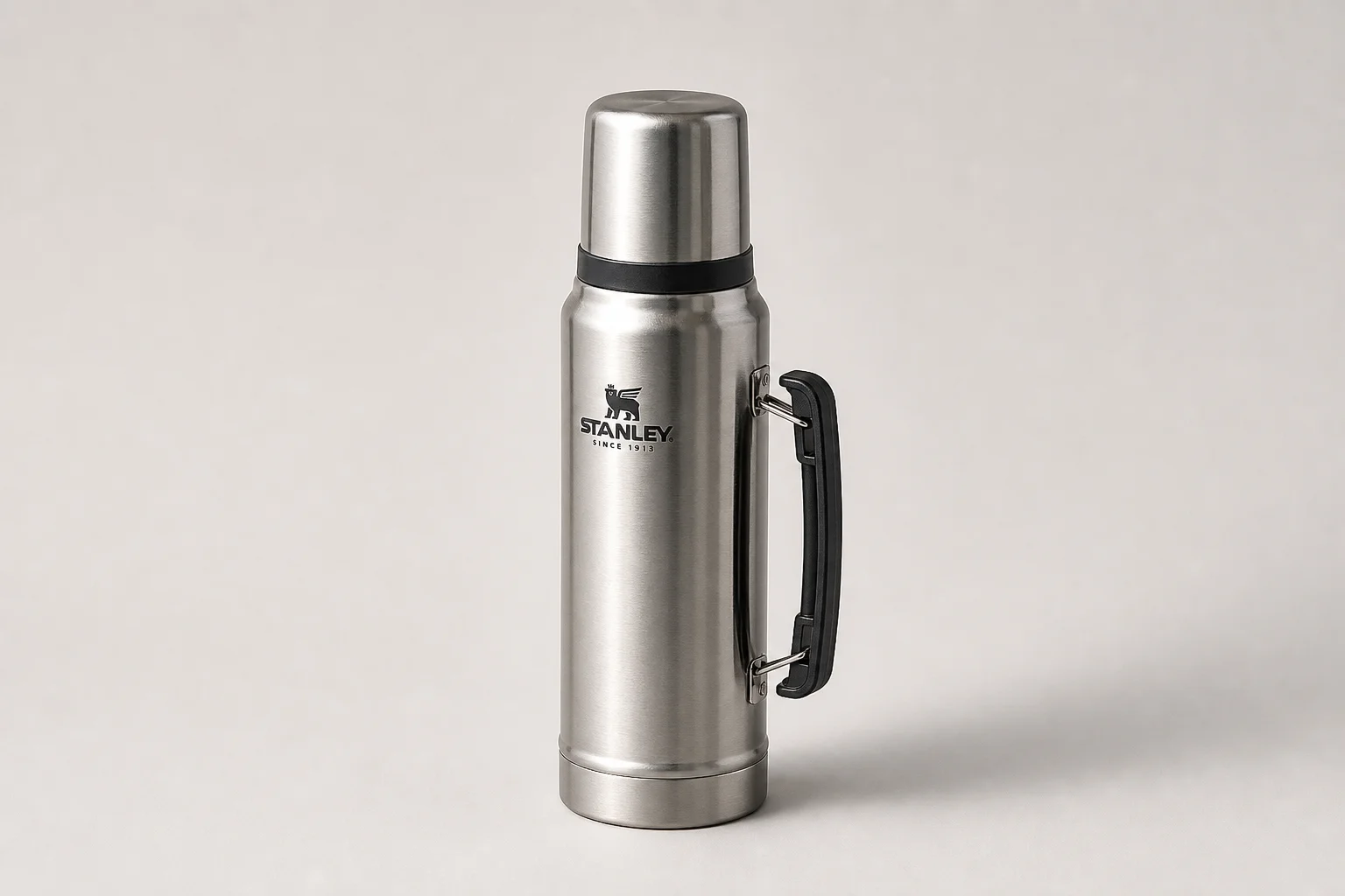 Collection of ten insulated bottles and travel mugs displayed on concrete surface