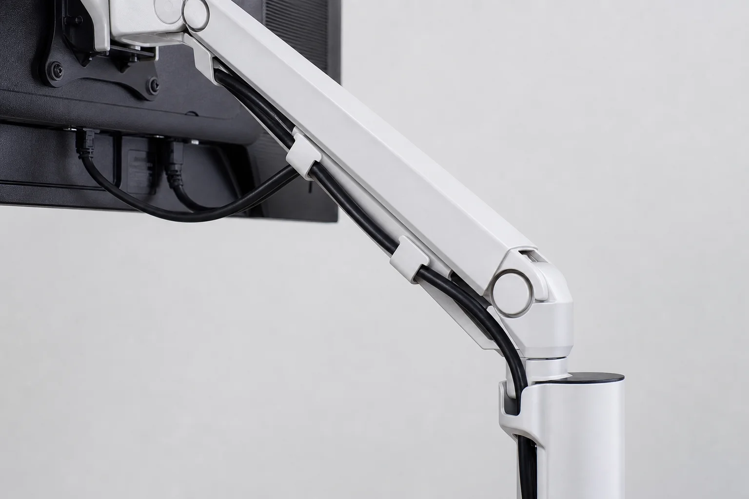 Brazo de monitor con clips de gestión de cables que organizan los cables de alimentación y video