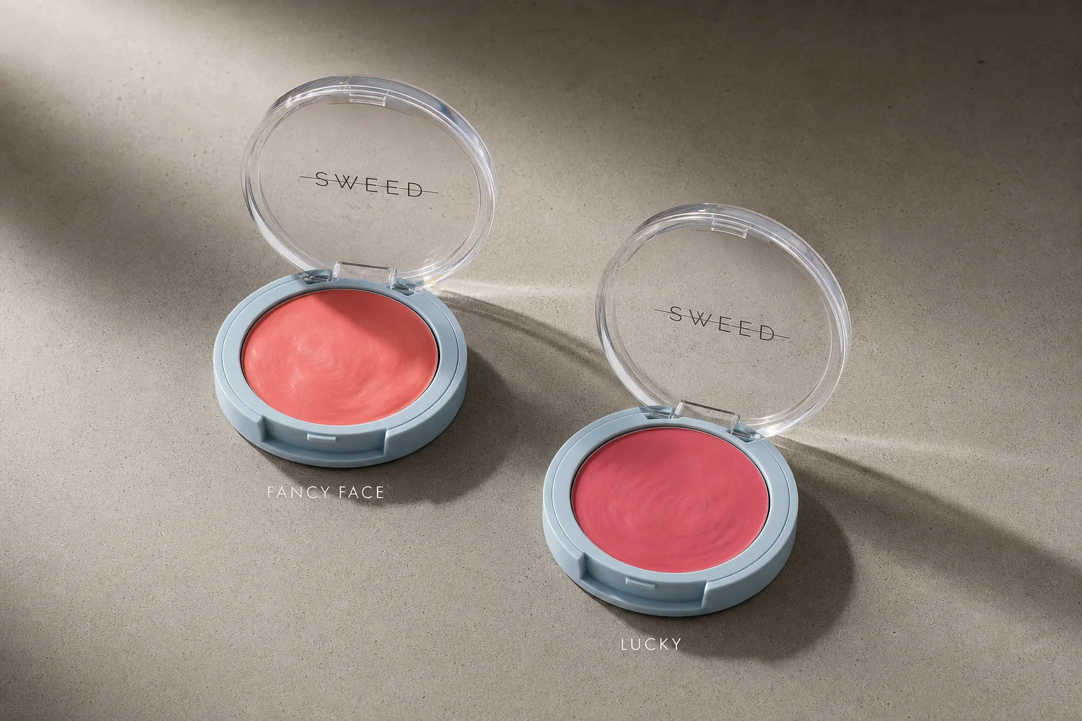Sweed Beauty makeup collection arranged on concrete surface showing foundation, powder, blush, lipstick, and mascara