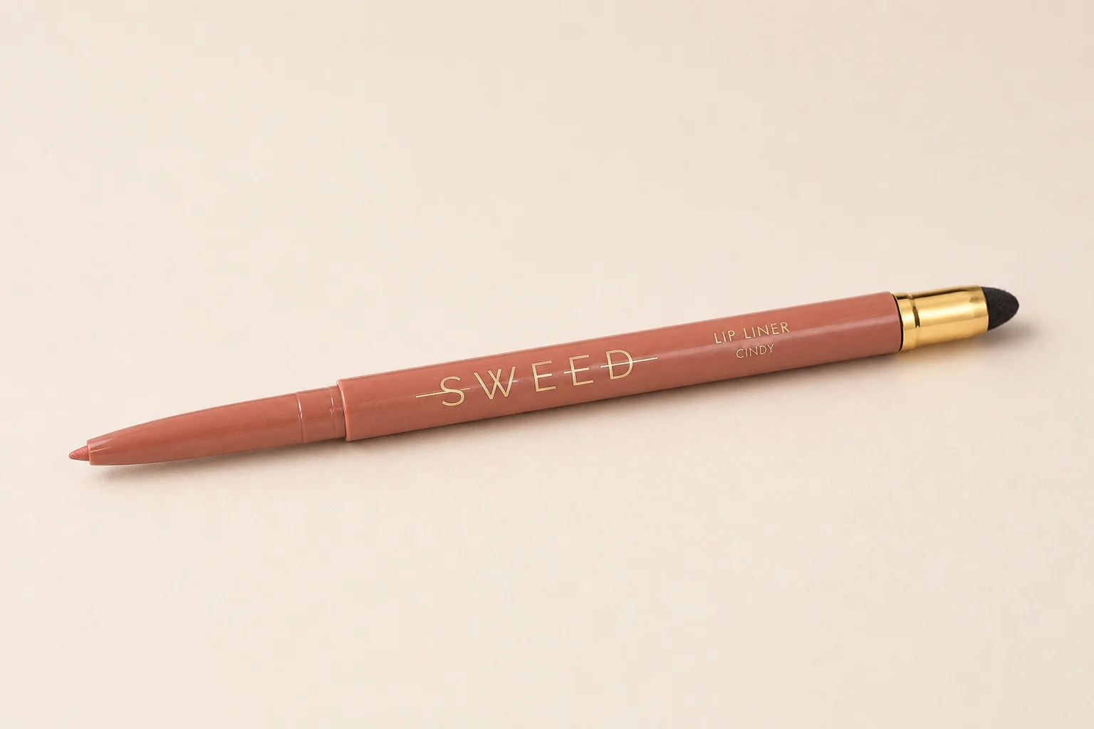 Sweed Beauty makeup collection arranged on concrete surface showing foundation, powder, blush, lipstick, and mascara