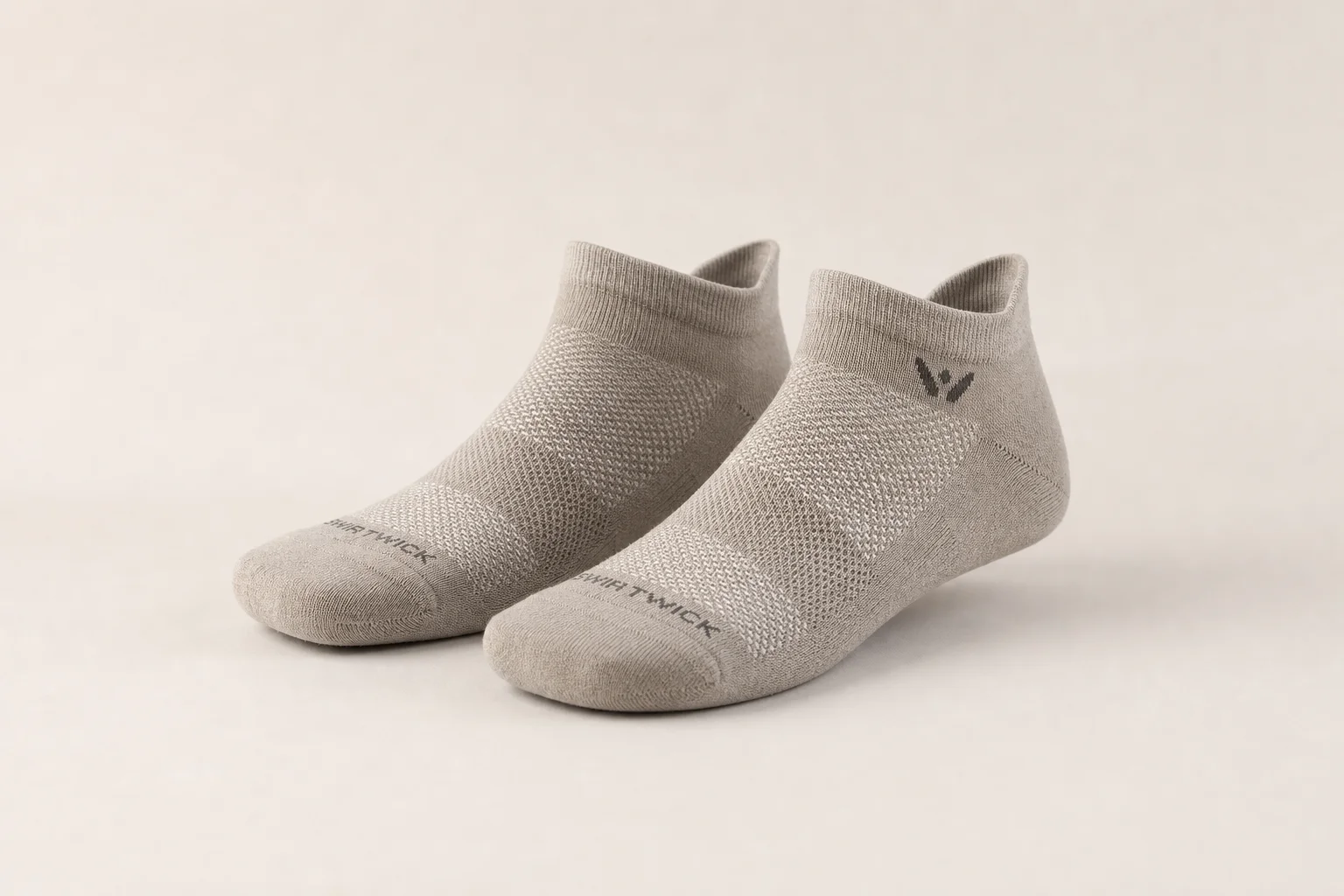 Collection of various running socks in different colors and styles on neutral backdrop