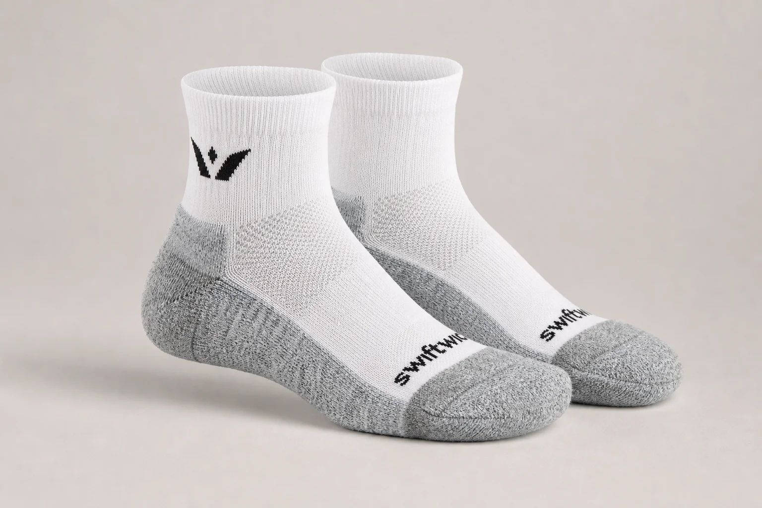 Collection of various running socks in different colors and styles on neutral backdrop