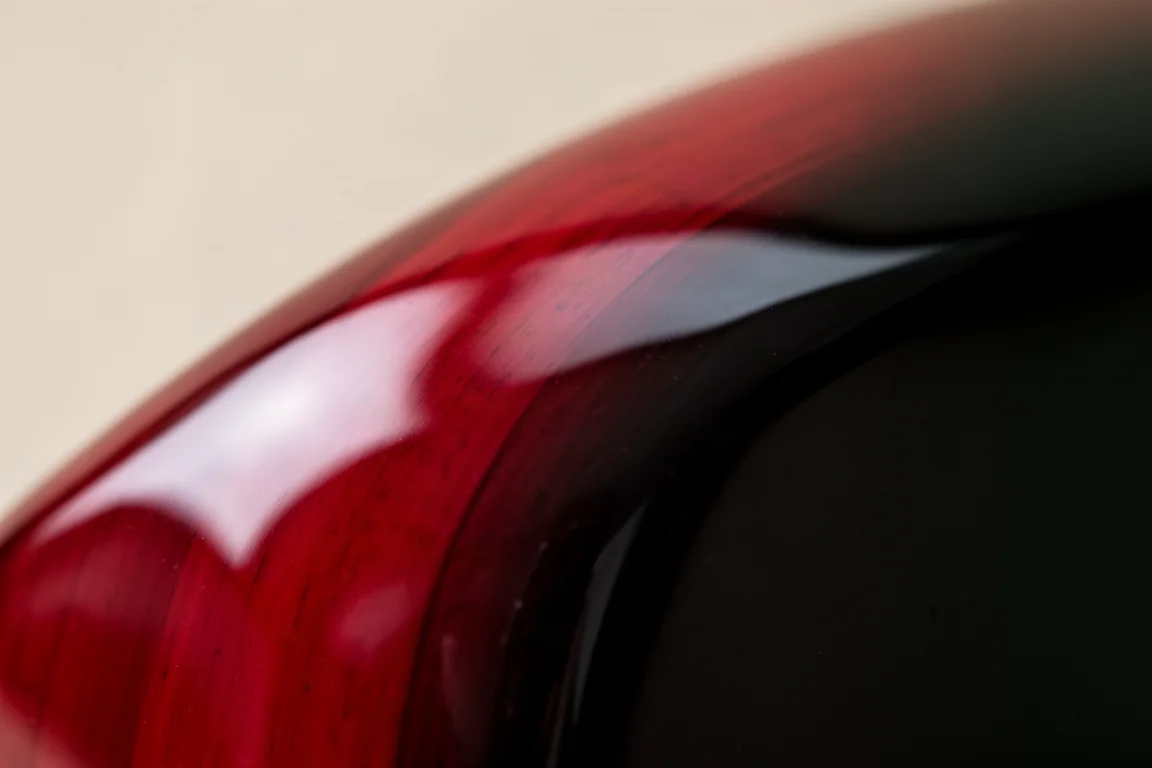 Gros plan sur une surface de laque brillante montrant un dégradé de rouge et de noir