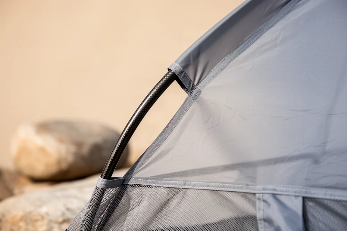 Ultralight backpackuitrusting plat op de grond: tentzak, carbon pole-segmenten en tentharingen