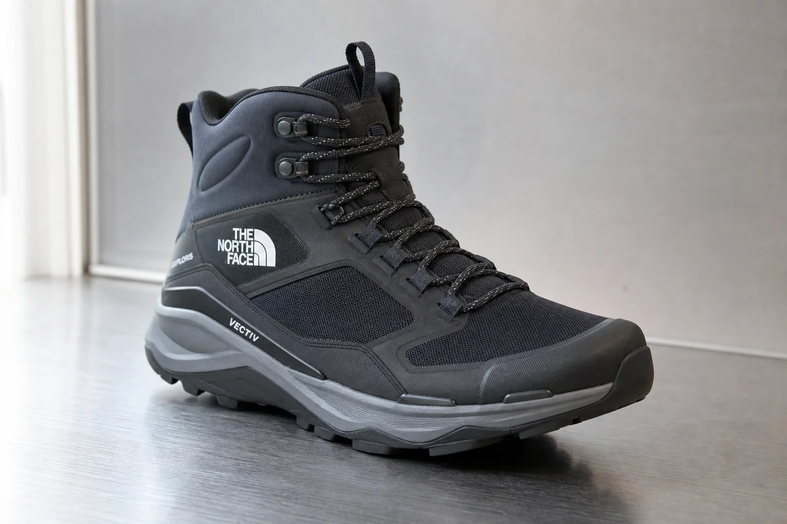 Seven hiking boots arranged on concrete surface representing different styles and purposes